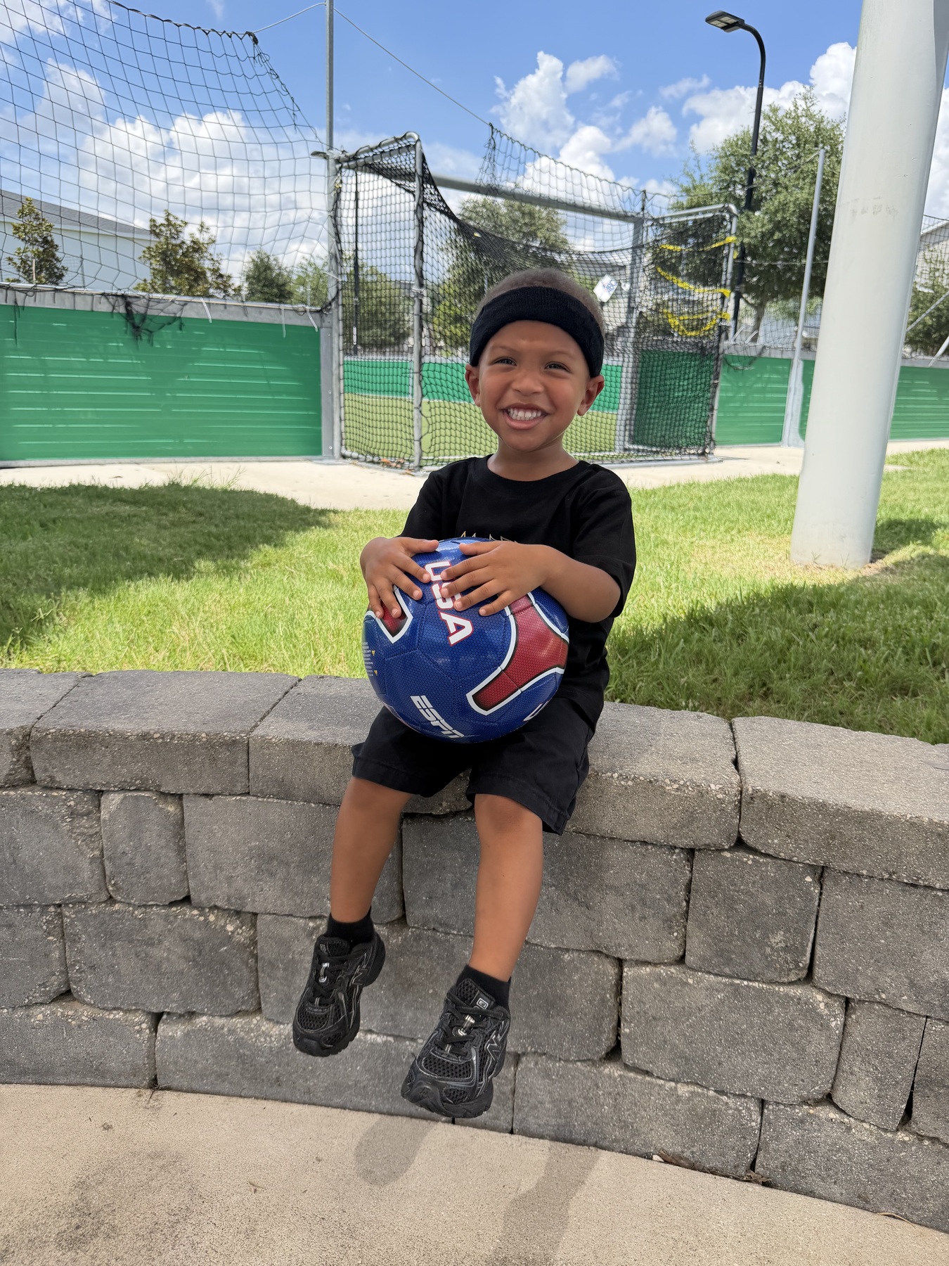 Young Anomalies athlete smiling with a soccer ball